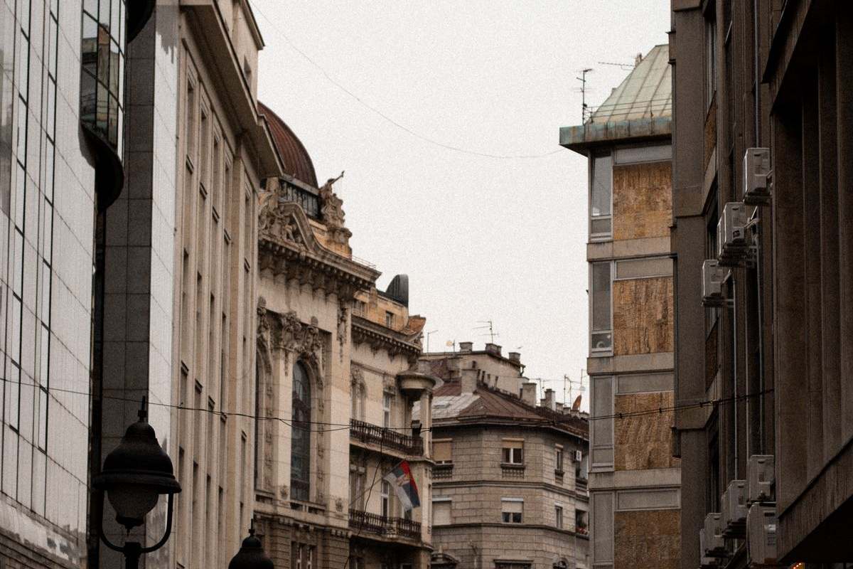 Symbolfoto: Straße mit historischen Gebäuden in Belgrad mit serbischer Flagge
