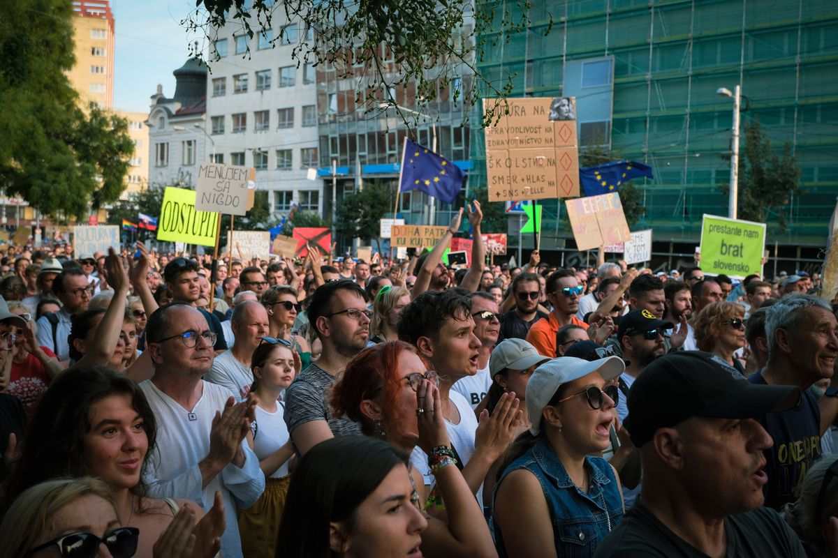Symbolfoto: Menschenmenge mit Schildern und Fahnen bei einer Demonstration auf einem Stadtplatz